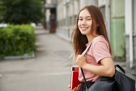 school girl with backpack and educational equipment. Student near university.の写真素材