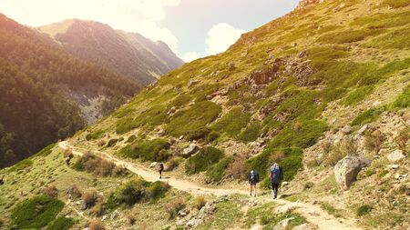 Group of hikers in the mountains. climbers with backpacks on trail.の写真素材