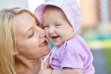 Portrait of a happy loving mother and her baby outdoors. Child and mom.の写真素材