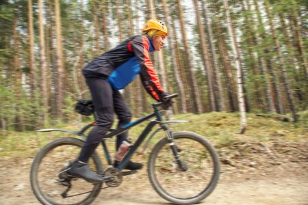 cyclist riding a mountain bike along the forest road.の写真素材