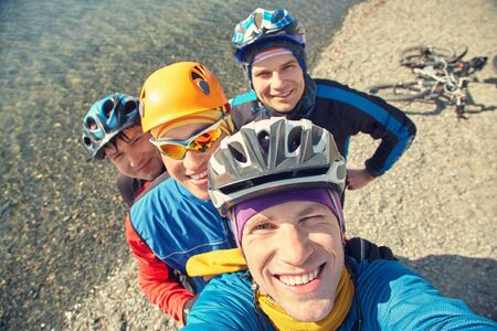group of cyclists in helmets taking selfie photo. team outdoors. mountain bike.の写真素材