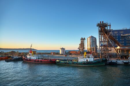 Ships in a cargo seaport at sunsetの写真素材