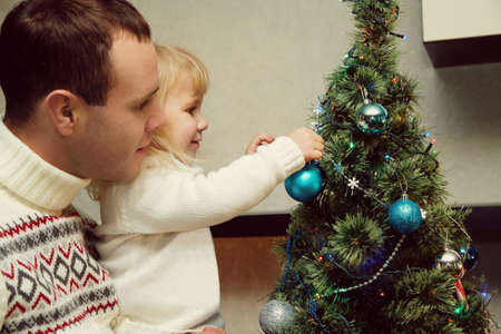 father and daughter decorating a Christmas treeの写真素材