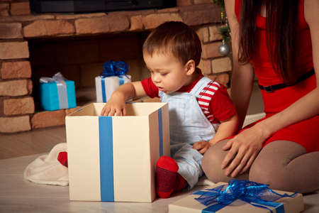 mother and child at Christmas time. Mom gives baby a gift. New Year and xmas peopleの写真素材