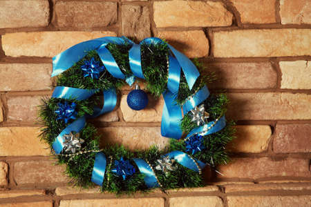Christmas wreath hanging on a brick wallの写真素材