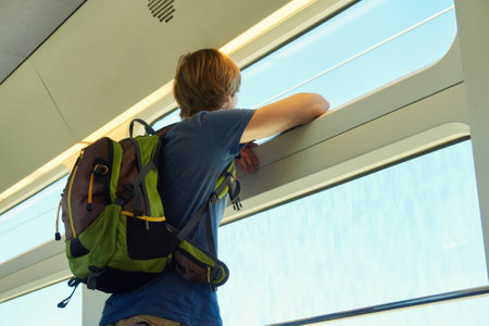 man with a backpack riding by train. traveler on the road looking out the window.の写真素材