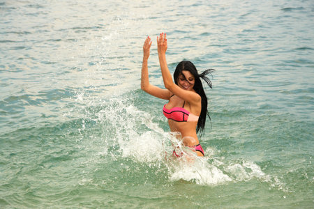 young attractive sexy woman playing in sea water.の写真素材