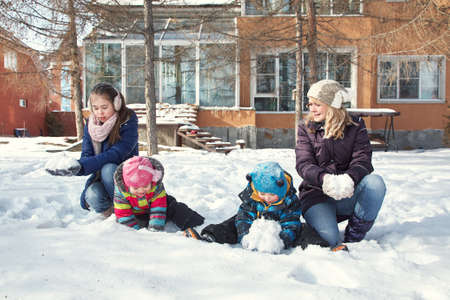 family playing with snow in the winter outdoorsの写真素材