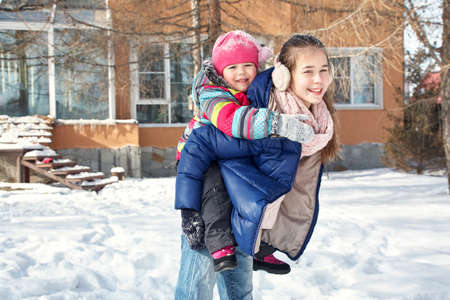 children playing in the yard of his house in the winter outdoorsの写真素材