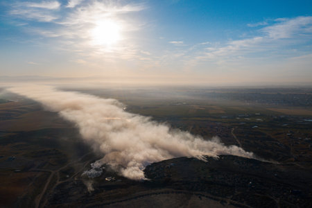Smoke from burning garbage pile in trash dump or landfill