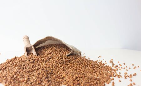 Stocks of buckwheat, bag, wooden scoop on a white background. Side view.の写真素材