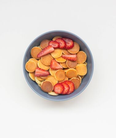 Pancake flakes with sliced strawberries in a gray bowl. Isolate Top view.の写真素材