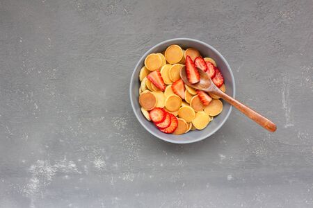Breakfast of mini pancakes with sliced strawberries on a gray background.の写真素材