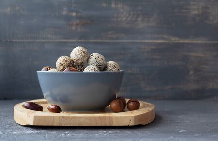 Energy balls of nuts and dates with sesame seeds in a gray bowl. Proper and tasty nutritionの写真素材