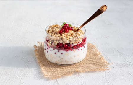 Granola with red currant berries and yogurt in a glass jar. Fitness breakfastの写真素材