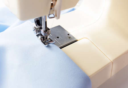 Sewing machine. Manufacture of wearing apparel. Blue fabric.の写真素材