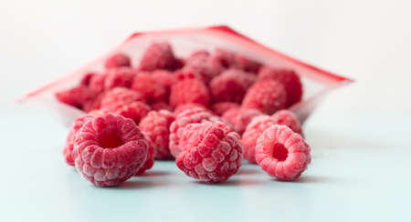 Frozen raspberries from a zip lock freezer bag.の写真素材