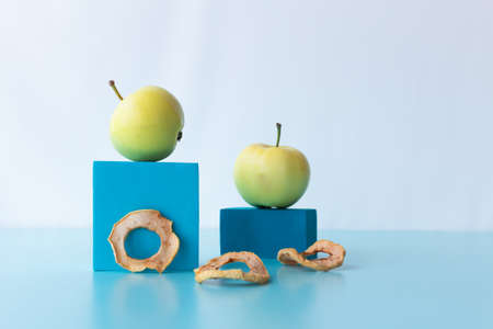 Homemade fresh and dried apples on blue cubes. A healthy snack for apple chips.の写真素材