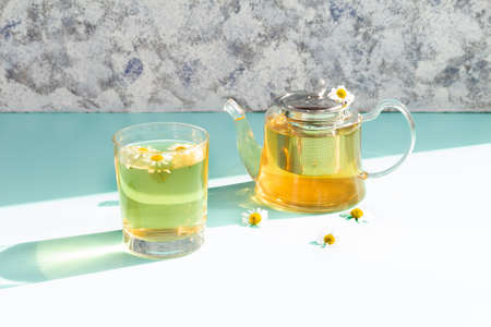 Chamomile tea in a glass teapot on a blue background.の写真素材