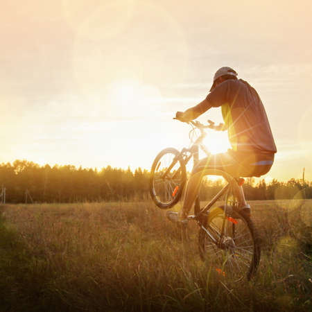 Sportsman riding a bike at sunset. Sport lifestyleの写真素材