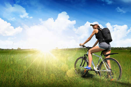 Girl rides a bike outdoors in the sunの写真素材