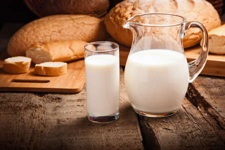 Jug with milk closeup on background breadの写真素材
