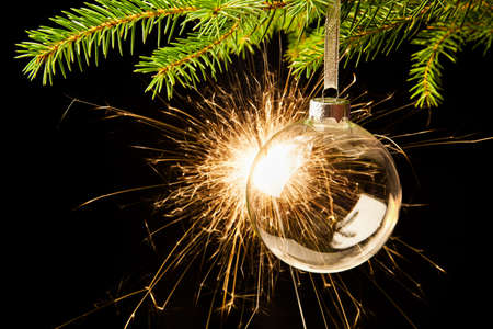 Christmas ball with a sparkler against a dark backgroundの写真素材