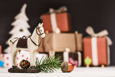 Christmas horse with spruce branches and fir cone closeup on dark background with giftsの写真素材