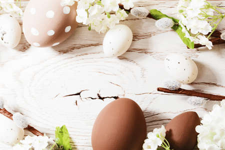 Easter decorations with spring flowers on white wood background