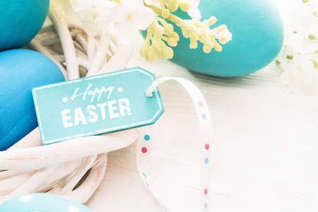 Easter decoration with eggs and  greeting label on white wooden backgroundの写真素材