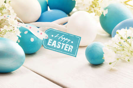 Easter decoration with eggs and  greeting label on white wooden backgroundの写真素材