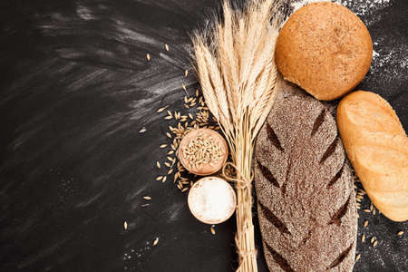 Fresh bread and wheat on black backgroundの写真素材