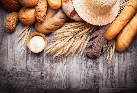 Fresh bread and wheat on black background