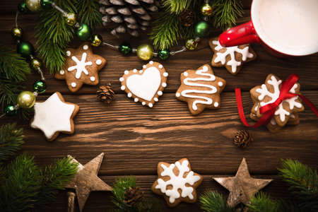 Christmas cookies with red ribbon and bow on wooden background