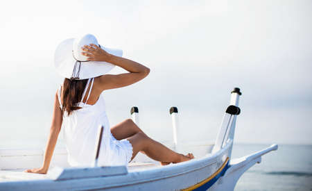 Young girl in hat sitting in boatの写真素材