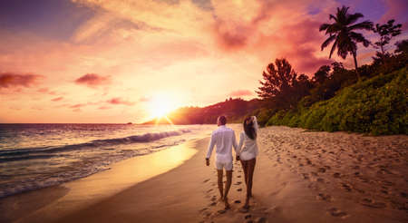 Young Happy Lovers on Beach. Couple Walking on Romantic Travel Honeymoon Vacation Summe Holidays Romance Sunsetの写真素材
