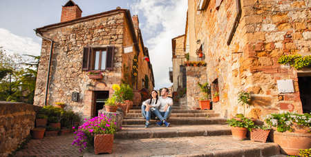 Beautiful Tourist Couple In Love Enjoying Rest In The Old City At Sunset. Happy Young Man And Woman Travel Conceptの写真素材