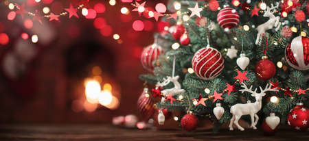 Christmas Tree with Decorations Near a Fireplace with Lightsの写真素材