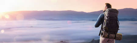 Happy Man in the Mountains Looking at the Sunset. Tourist in Mountain Peak. Travel Conceptの写真素材