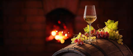 White Wine and Grapes on the Background of the Fireplaceの写真素材