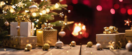 Christmas Tree with Gifts Near a Fireplace with Lightsの写真素材