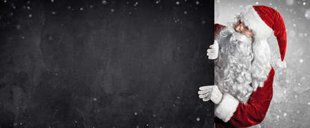 Santa Claus Showing Something On a Black Wallの写真素材
