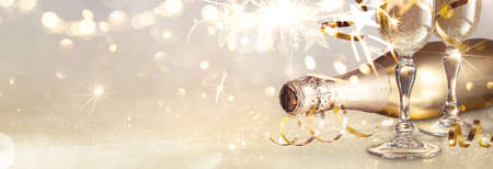 New Years Eve Celebration with Champagne and Sparklers. Gold Glitter backgroundの写真素材