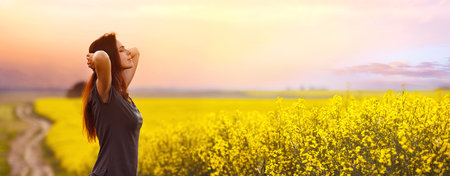 Happy woman relaxing outdoors on sunset backgroundの写真素材