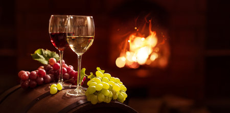 White and red wine on the background of the fireplaceの写真素材