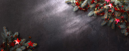 Christmas Decoration with Fir Branches and Red Stars on a Dark Backgroundの写真素材