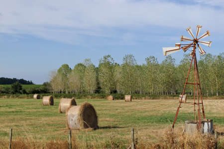 wind pump and haystacks in a field scene of local agriculture in the vicinity of  pauillac   franceの写真素材