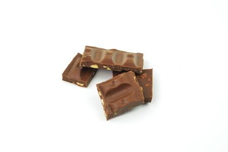 Pieces of chocolate on white background. Brown chocolate. Isolated chocolate with nutsの写真素材