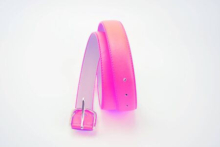 Pink rolled belt with a golden buckle on the white background. Valentine present. Good present for women. Women accessoriesの写真素材