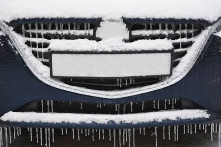 Auto with snow and ice. Many icicles on a blue car.の写真素材